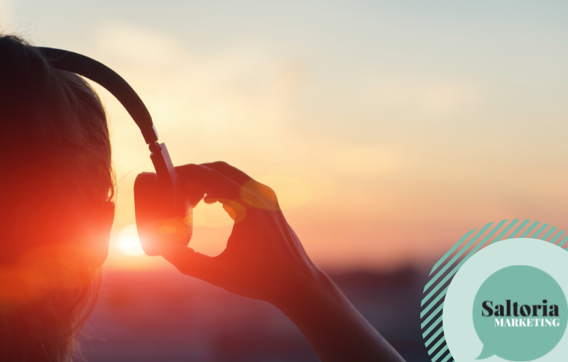 Person with headphones looking at the sun - demonstrating a customer listening to a brand tone of voice