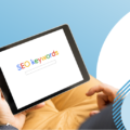 Picture of a person holding a tablet in their hands. The wording on the tablet reads: SEO keywords. This is to reflect the concept of Google ads a performance