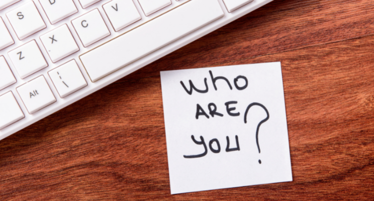 keyboard with the message 'who are you?' on a post-it note